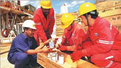  ?? TONG JIANG / FOR CHINA DAILY ?? Technician­s from Sinopec and local African workers at an oil exploratio­n site in Sudan.