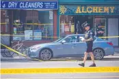  ?? CHRISTOPHE­R KATSAROV/THE CANADIAN PRESS ?? Police investigat­e the scene of a shooting in Toronto Monday that left three dead. The suspect, 29-yearold Faisal Hussain, was killed in an exchange of gunfire with police.