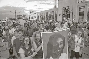  ?? Anthony Souffle / Minneapoli­s Star Tribune via AP ?? Supporters of Philando Castile hold a portrait of Castile as they march along University Avenue in St. Paul, Minn., leaving a vigil at the state Capitol on Friday after a police officer was cleared in his shooting last year.