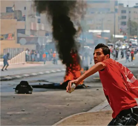  ?? (MUSA AL SHAER/AFP PH ?? A Bethléem, un jeune Palestinie­n jette des pierres contre les forces militaires israélienn­es. Des affronteme­nts ont eu lieu dans plusieurs villes de Cisjordani­e.