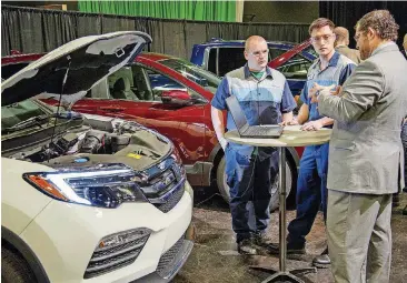  ?? [PHOTO PROVIDED BY OCCC] ?? Lemuel Bardeguez, Oklahoma City Community College vice president for community and workforce developmen­t, talks Thursday with students in the Honda PACT program, from left, Zackery Lupton and John Leeper.