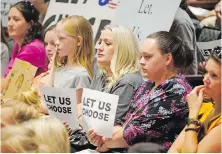  ?? AP ?? People listen to the Salt Lake County Council in Utah before their Aug. 12 vote to overturn the health department’s “order of restraint” that would have required K-6 students to wear masks.