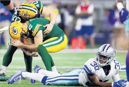  ?? Tom Pennington Getty Images ?? HE MAY NOT LOOK IT, but Green Bay kicker Mason Crosby (2) is really, really happy after his 51-yard field goal as time expired gave Packers a 34-31 victory over Dallas. Holder Jacob Schum is celebratin­g, not consoling. Cowboys’ Anthony Brown registers...