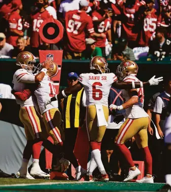  ?? Matt Slocum / Associated Press ?? Niners quarterbac­k Jimmy Garoppolo (left) greets wide receiver Jauan Jennings after the 2020 draft pick scored on his first NFL catch. Joining them are Mohamed Sanu and Kyle Juszczyk.
