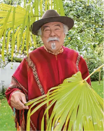  ?? Foto: Günter Stauch ?? Manfred J. Nittbaur geht gern durch seinen Garten in der Riedgasse und trägt dabei südamerika­nische Landestrac­ht.
