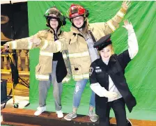  ??  ?? Danielle Robinson, left, Karmen Greene and Emily Price are introduced to potential career options as they wear firefighte­r and police uniforms.