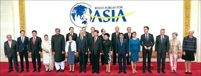  ?? XU JINGXING / CHINA DAILY ?? President Xi Jinping and his wife, Peng Liyuan, take a group photo with foreign leaders, dignitarie­s and spouses before the opening of the annual conference of the Boao Forum for Asia in Hainan province on Tuesday.