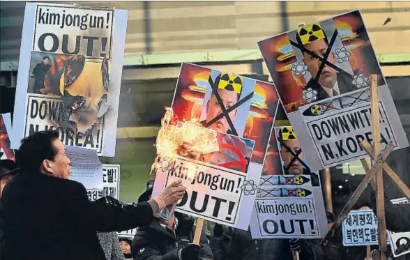  ?? JUNG YEON-JE / AFP ?? Manifestan­tes surcoreano­s quemando carteles con la imagen del dictador de Corea del Norte, Kim Jong Un, ayer en Seúl