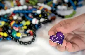  ??  ?? Some of the treatment beads Sam collected during his illness. A purple heart recognises the end of a long battle.