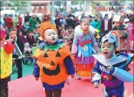  ?? CHEN DONGDONG / FOR CHINA DAILY ?? Kids in Mianyang, Sichuan, in costumes of wastes and paper they made together with parents, play games in an environmen­tal protection promotiona­l event.