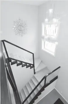  ??  ?? The staircase leading to the home’s second floor features a contempora­rystyled wood rail, with accenting tread caps and glass panels.