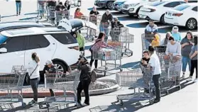  ?? JOHN LOCHER/AP ?? People wait in line to buy supplies at a Costco on Saturday in Las Vegas.