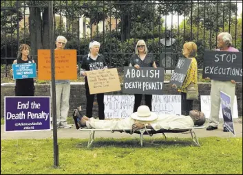  ?? The Associated Press ?? Pulaski County Circuit Judge Wendell Griffen is strapped to a cot, representi­ng a prison gurney, while taking part in an anti-death penalty demonstrat­ion outside the Arkansas governor’s mansion on Friday in Little Rock.