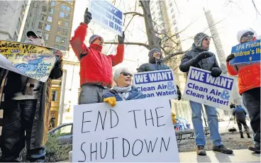  ?? (AFP) ?? Protesters hold signs during a rally by government workers and citizens against the government shutdown, in Boston on Friday