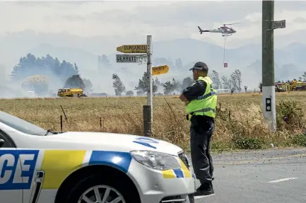  ?? PHOTOS: JOSEPH JOHNSON/STUFF ?? Police set up cordons around the fires and evacuated up to 10 houses.