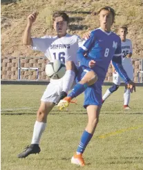  ?? JAMES BARRON/THE NEW MEXICAN ?? St. Michael’s senior midfielder Wesley Sage Graham, right, and Santa Fe Prep’s Alex Mazur battle for the ball Friday during the Class 1A/3A State Boys Soccer Championsh­ip first-round match. St. Michael’s won, 2-0.