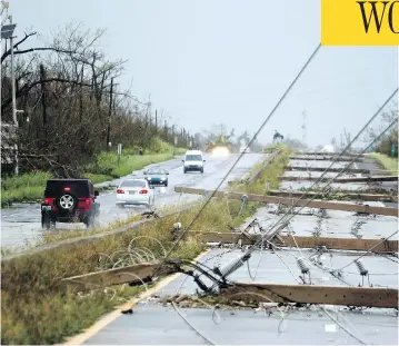  ?? RICARDO ARDUENGO / AFP / GETTY IMAGES ?? Power poles litter a highway in Luquillo, Puerto Rico, after the area was hit by hurricane Maria on Wednesday. No deaths have yet been reported in the U.S. territory, despite widespread flooding and winds of up to 250 km/h.