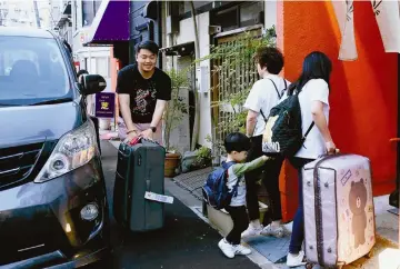  ??  ?? Travellers from Hong Kong arrive at a private lodging facility in Sumida Ward, Tokyo. — Japan News photo