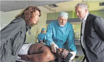  ?? FOTO: HUBERT MICAN/ARD ?? Für die Wiener „Tatort“-Kommissare sind die Ferien vorbei. Moritz Eisner (Harald Krassnitze­r, rechts) und Bibi Fellner (Adele Neuhauser) lassen sich von Gerichtsme­diziner Kreindl (Günter Franzmeier) erklären, woran der Flüchtling gestorben ist. Ladi Di...