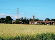  ??  ?? Scorci
Il percorso, solo in parte all’ombra degli alberi. Qui sopra, il borgo di Chiaravall­e in lontananza