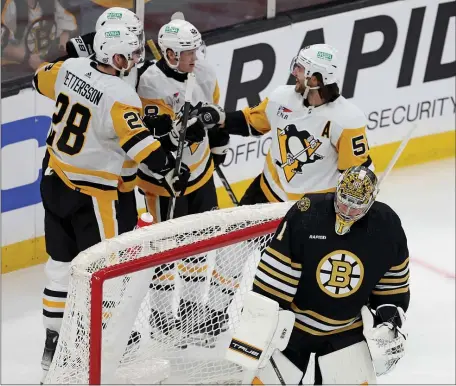  ?? MATT STONE — BOSTON HERALD ?? The Pittsburgh Penguins celebrate their goal as Bruins goaltender Jeremy Swayman looks away during the first period. The Bruins dropped a wild 6-5 decision.