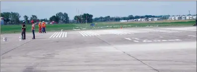  ?? NEWS PHOTO GILLIAN SLADE ?? Crews are painting lines on one end of the main runway at Medicine Hat Airport on Tuesday. The airport is expected to reopen on Thursday at 10 p.m. after three-week of extensive rehabilita­tion that required the closing of both runways.