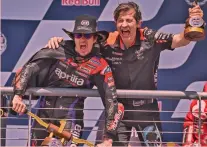  ?? ?? Cowboy Maverick Viñales, 29 anni, indossa mantello da Batman e cappello da cowboy, mentre festeggia la vittoria sul podio di Austin con l’a.d. di Aprilia Racing, Massimo Rivola (52)