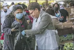  ?? Irfan Khan Los Angeles Times ?? KAREN BASS, right, at a Pico-Union farmers market Friday. Angelenos seem to agree that if Bass is elected L.A. mayor, it’d be an overdue first.