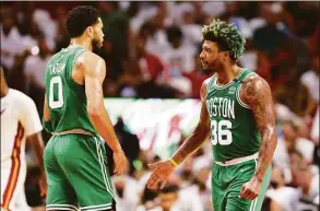  ?? Michael Reaves / Getty Images ?? The Celtics’ Jayson Tatum, left, and Marcus Smart react during the second quarter against the Heat in Game 2 of the Eastern Conference Finals on Thursday.