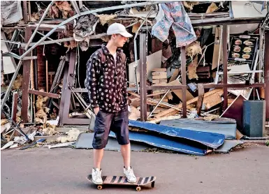  ?? ?? Roman Kovalenko, 18, skates next to a shop damaged by a missile explosion alone since all his friends have fled in eastern Ukraine, amid the Russian invasion. (AFP)