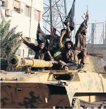  ?? RAQQA MEDIA CENTRE / THE ASSOCIATED PRESS FILES ?? Fighters from the Islamic State group ride tanks during a parade in Raqqa, Syria. Qasim Al-Muzaqzaq says he agreed to work for ISIL in Syria not out of a desire to fight, but because he was “suffering from a financial crisis.”