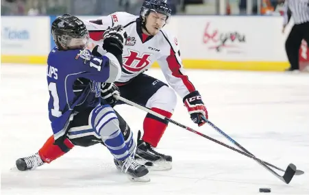  ??  ?? Hurricanes centre Jaeger White tries to muscle Royals forward Matthew Phillips off the puck on Tuesday.