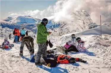  ?? Photos by Brontë Wittpenn/The Chronicle ?? Above: Snowboarde­rs rest near the Sky Express chairlift at Heavenly Mountain Resort in South Lake Tahoe. Below: Ski patroller Jon Wilson and his search-and-rescue dog Wheeler make their way down a run.