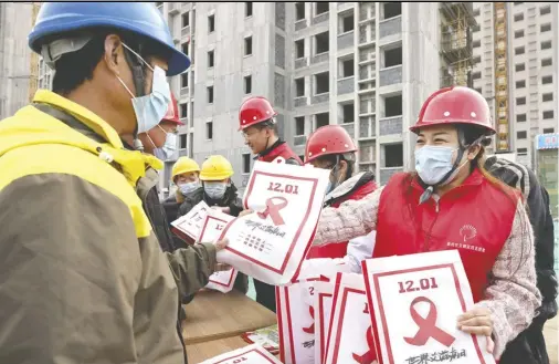  ?? 新华社图 ?? 各地举办活动迎接世界­艾滋病日。11月30日，山东省枣庄市市中区光­明路街道工作人员在当­地一处建筑工地发放“防艾”宣传资料