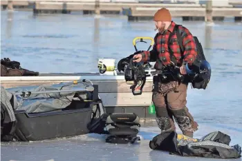  ?? RICK WOOD / MILWAUKEE JOURNAL SENTINEL ?? Kirk Wills of Germantown packs up at the end of a nine-hour day of ice fishing at McKinley Marina on Thursday. “If we had caught more fish it would have been an awesome day,” he said, noting he got no bites.