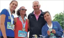  ?? ALISON LANGLEY THE NIAGARA FALLS REVIEW ?? Bernadette Miszk celebrates with her family after crossing the finish line at the Niagara Falls Women’s Half Marathon, Sunday.