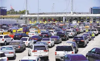  ?? ALEJANDRO TAMAYO U-T PHOTOS ?? Long lines of traffic form in lanes on the Tijuana side of the San Ysidro border crossing on Friday. When crossing restrictio­ns first went into effect, border traffic fell by 70 percent, according to the CBP.