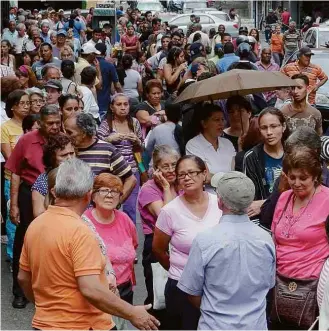  ?? Carlos Garcia - 16.mar.2016/Reuters ?? Venezuelan­os fazem fila para comprar alimentos básicos em supermerca­do de Caracas