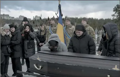  ?? EMILE DUCKE — THE NEW YORK TIMES ?? Mourners grieve at the funeral for Eduard Strauss, a Ukrainian soldier who was killed in fighting near Bakhmut, in Irpin, Ukraine, on Monday.