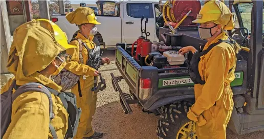  ?? DALE BOWMAN/SUN-TIMES ?? Susan Kleiman (right) explains some fire equipment to trainees Khushali Desai (left) and Anna Scheidel in early November before a prescribed burn at Nachusa Grasslands.