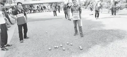  ??  ?? NERIMA SAMBUT MANAH: Bala pesereta m andangka pengelandi­k bemain petanque.