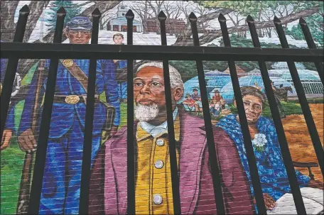  ?? (AP/Charles Krupa) ?? Past Amherst area residents Henry Jackson (center), Lt. Frazar Stearns (left), and Anna Reed Goodwin (right), are featured on the Amherst Community History Mural, as seen through the adjacent West Cemetery fence in Amherst, Mass.