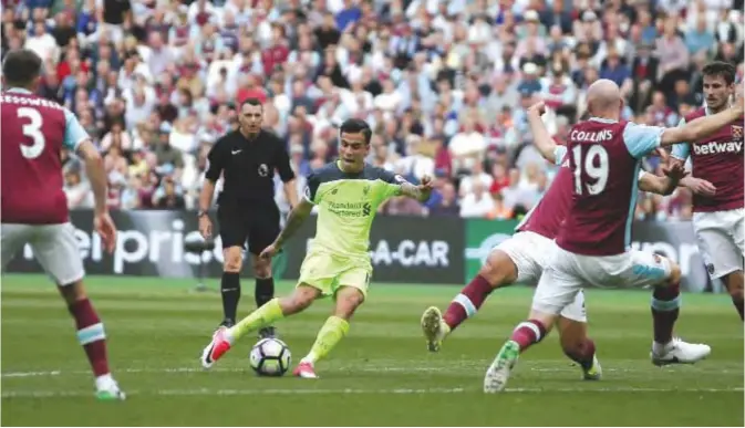 ??  ?? LONDON: Liverpool’s Brazilian midfielder Philippe Coutinho (C) shoots past West Ham United’s Welsh defender James Collins (2R) to score the team’s second goal during the English Premier League football match between West Ham United and Liverpool at The...