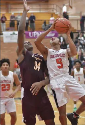  ?? MARK NANCE — FOR MEDIANEWS GROUP ?? Coatsville’s Dymere Miller (5) shoots around Kennedy Catholic’s Oscar Tshiebwe in the third quarter Tuesday at Williamspo­rt Area High School.