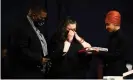  ??  ?? Aubrey and Katie Wright receive a flag presented by Ilhan Omar during the funeral. Photograph: Stephen Maturen/Getty Images