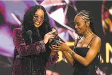  ?? Kevin Winter / via Getty Images ?? Gabriella Wilson (left), also known as H.E.R., accepts the song of the year Grammy with Tiara Thomas for “I Can’t Breathe.”