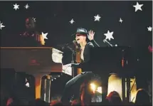  ??  ?? AT THE KEYBOARDS as well as playing host, Keys sits down at the piano to perform at the 61st Grammy Awards show.