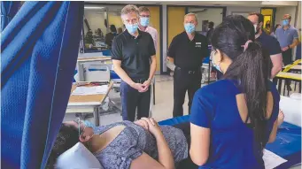  ?? ERROL MCGIHON ?? Ontario Long-Term Care Minister Rod Phillips, left at top, talks with PSW students at Algonquin College on Thursday. He says the government has a “very aggressive plan” to add more long-term care staff.