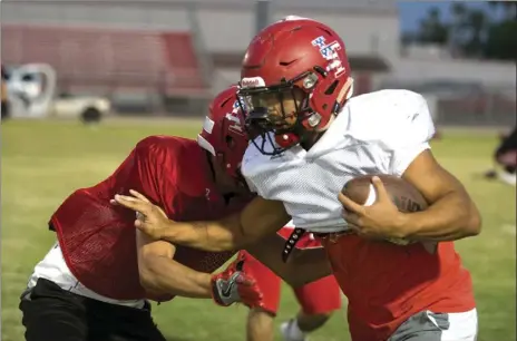  ?? VINCENT OSUNA PHOTO ?? Imperial High running back Brandon Hueso performs a stiff arm move while running the ball during their team practice in Imperial on Wednesday evening.