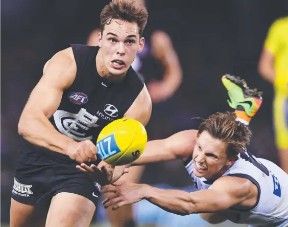  ?? Picture: GETTY IMAGES ?? Carlton’s David Cuningham handballs away from Lachie Whitfield of the Giants during their match at Etihad Stadium yesterday.